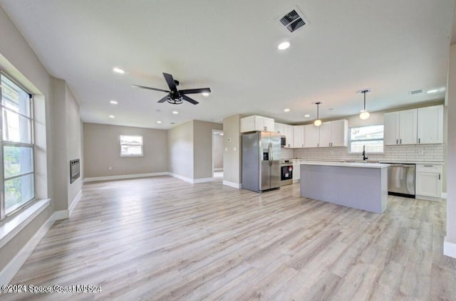 kitchen with plenty of natural light, white cabinetry, and appliances with stainless steel finishes