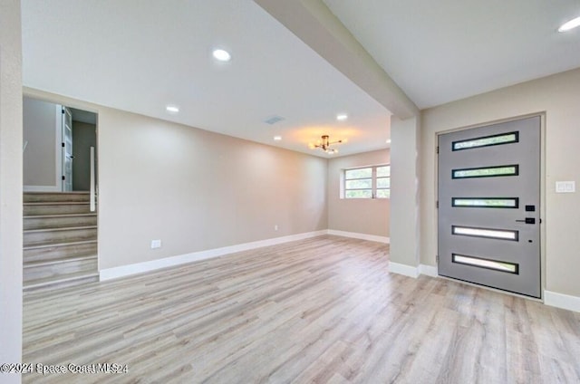 entrance foyer with light wood-type flooring and a chandelier