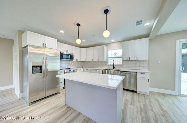 kitchen featuring pendant lighting, white cabinets, sink, and appliances with stainless steel finishes