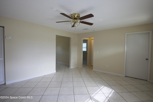 spare room with ceiling fan and light tile patterned flooring