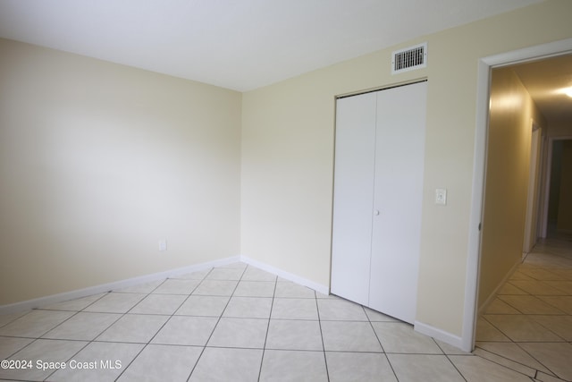 unfurnished bedroom featuring a closet and light tile patterned floors