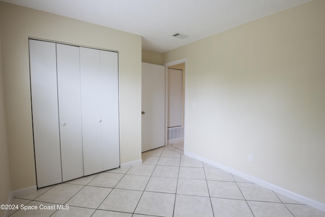 unfurnished bedroom with light tile patterned floors and a closet