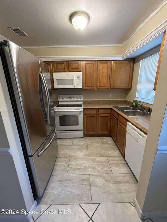 kitchen with crown molding, white appliances, and sink