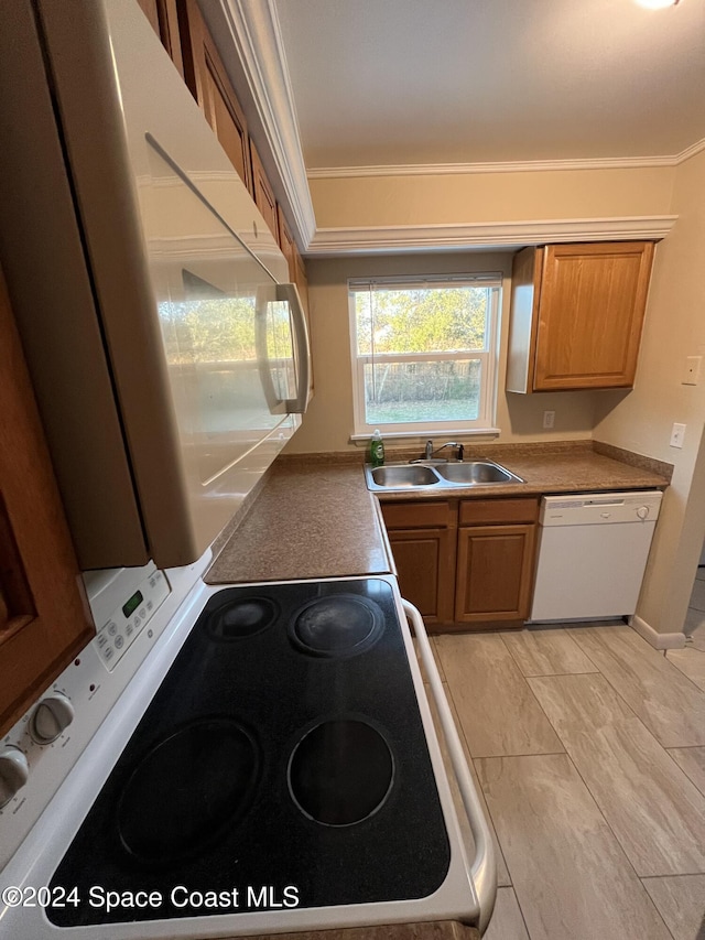 kitchen featuring white appliances, ornamental molding, and sink