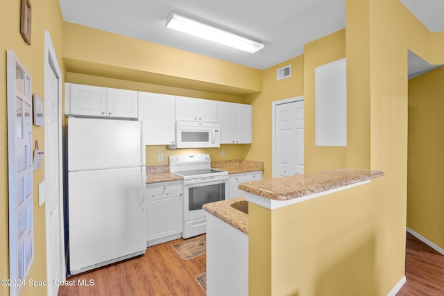 kitchen featuring white cabinetry, kitchen peninsula, light hardwood / wood-style floors, white appliances, and a breakfast bar area