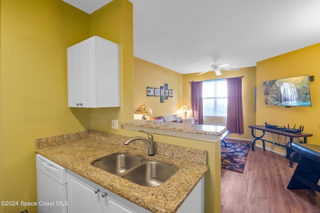 kitchen with kitchen peninsula, white cabinetry, sink, and wood-type flooring