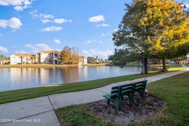 surrounding community with a water view and a yard