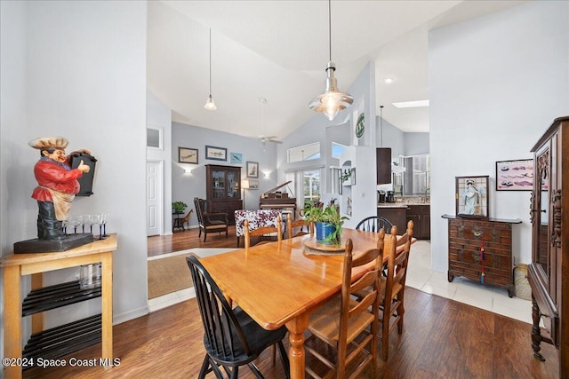 dining space featuring light hardwood / wood-style floors, high vaulted ceiling, and ceiling fan