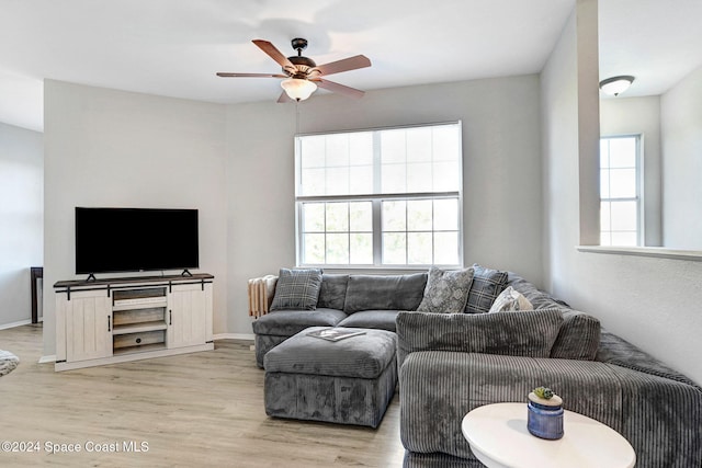 living room featuring light wood-type flooring, plenty of natural light, and ceiling fan