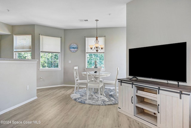 dining area featuring a chandelier and light hardwood / wood-style flooring