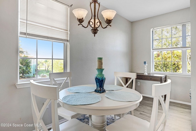 dining room with hardwood / wood-style floors, an inviting chandelier, and a wealth of natural light