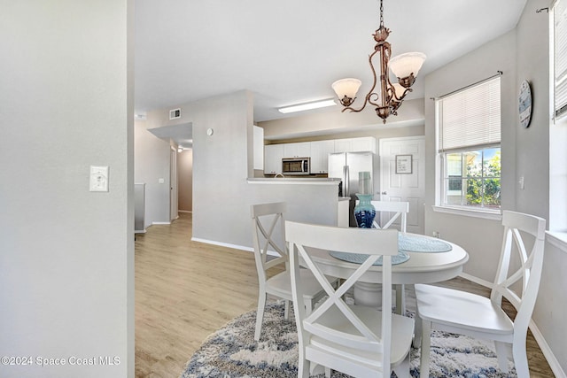 dining space featuring a notable chandelier and light hardwood / wood-style flooring