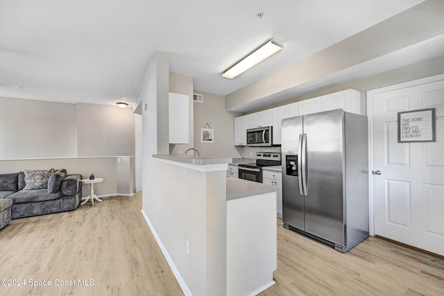 kitchen with white cabinets, appliances with stainless steel finishes, light hardwood / wood-style floors, and kitchen peninsula