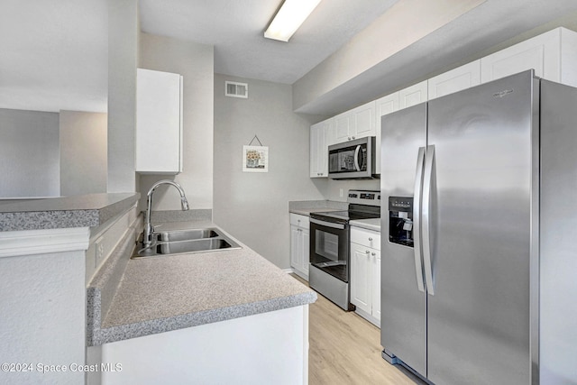 kitchen with light hardwood / wood-style floors, sink, white cabinetry, and stainless steel appliances