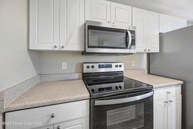 kitchen with white cabinets and appliances with stainless steel finishes