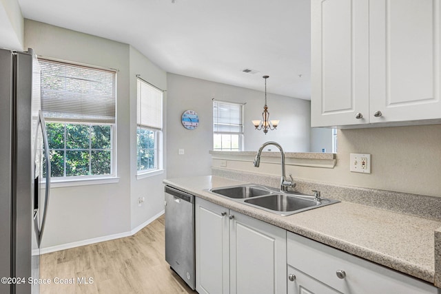 kitchen featuring appliances with stainless steel finishes, light wood-type flooring, a wealth of natural light, and sink