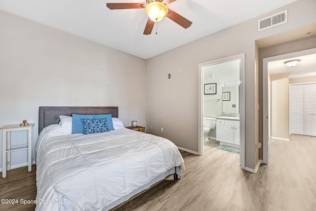 bedroom with hardwood / wood-style floors, ceiling fan, and ensuite bathroom