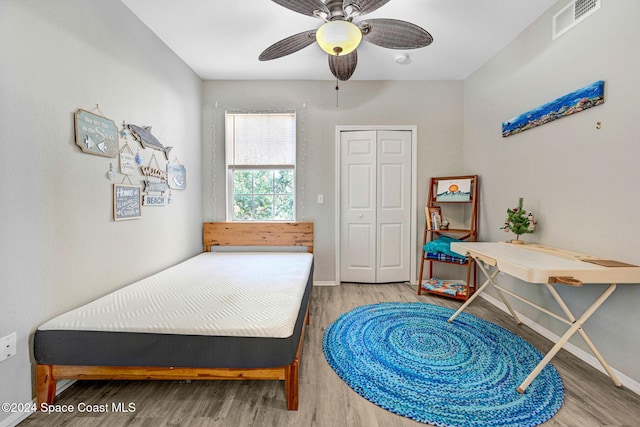 bedroom featuring ceiling fan, wood-type flooring, and a closet