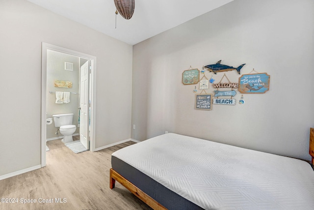 bedroom featuring connected bathroom and light hardwood / wood-style flooring