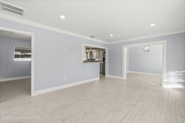 spare room featuring light hardwood / wood-style flooring and ornamental molding