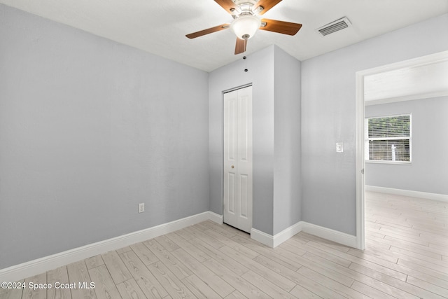 unfurnished bedroom with light wood-type flooring, a closet, and ceiling fan