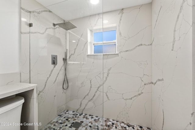 bathroom with toilet and a tile shower