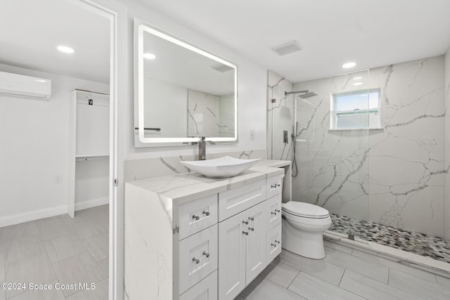 bathroom with a wall mounted air conditioner, vanity, tiled shower, and toilet