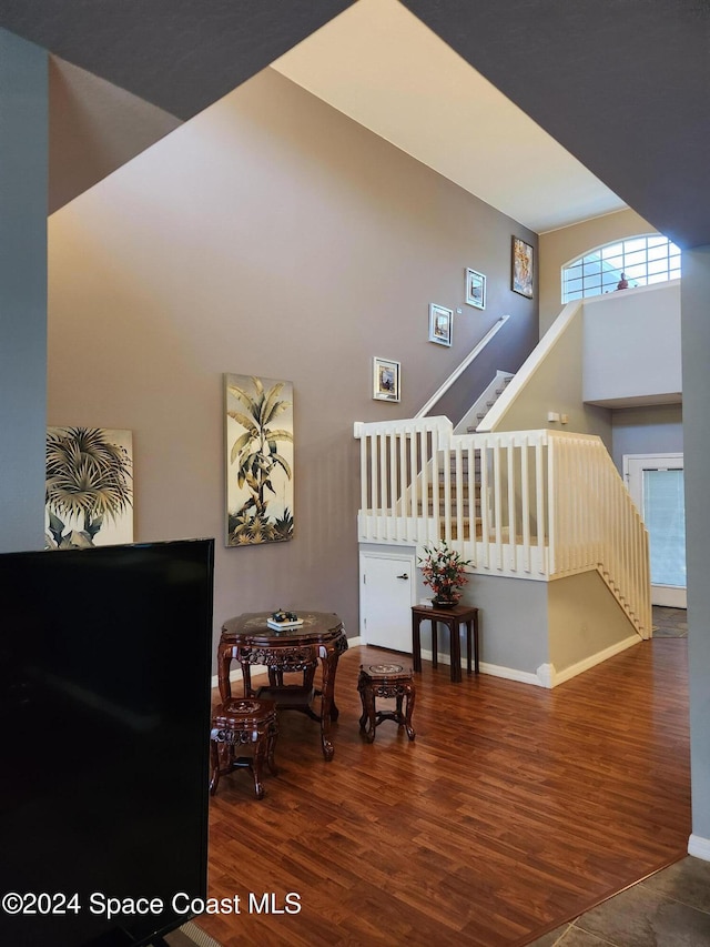 interior space with hardwood / wood-style floors and a towering ceiling