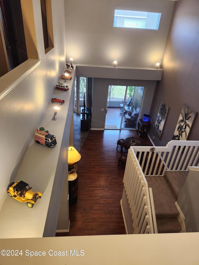 interior space with a towering ceiling and dark hardwood / wood-style floors