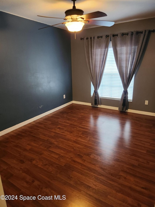 unfurnished room featuring ceiling fan and dark wood-type flooring