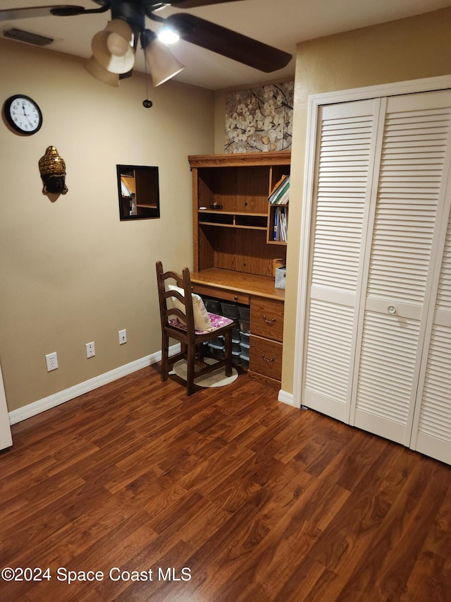 office space with ceiling fan, built in desk, and dark wood-type flooring