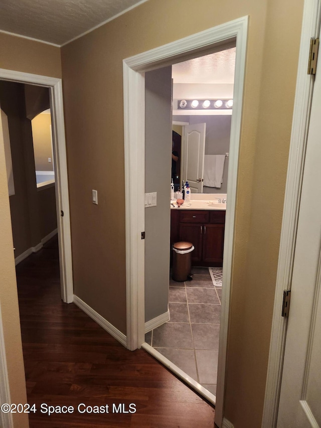 corridor with dark hardwood / wood-style flooring and sink