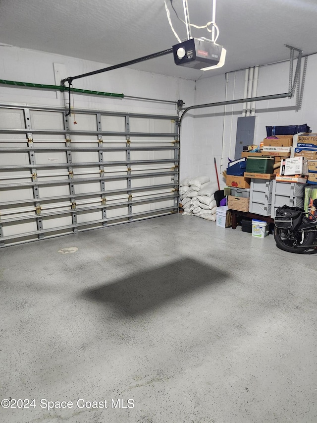 garage featuring electric panel and a garage door opener