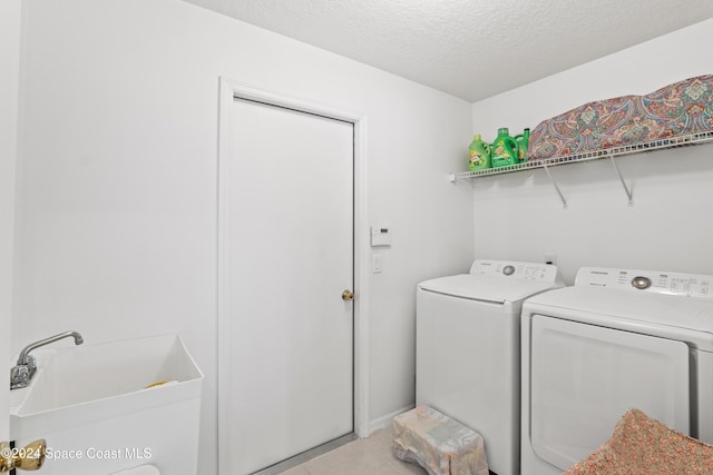 laundry area featuring separate washer and dryer and a textured ceiling