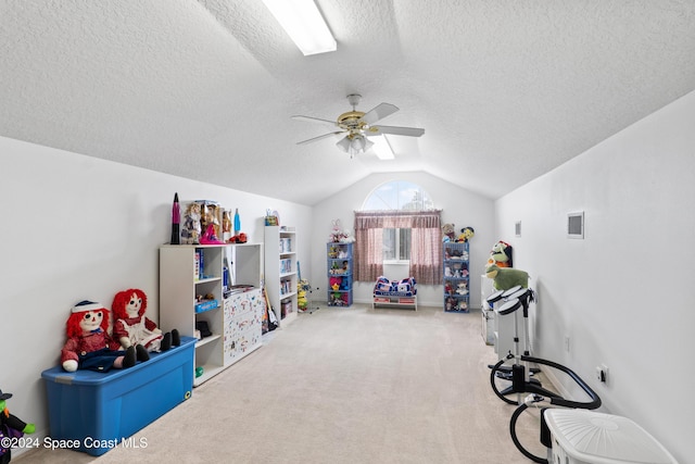 recreation room with carpet, ceiling fan, a textured ceiling, and vaulted ceiling