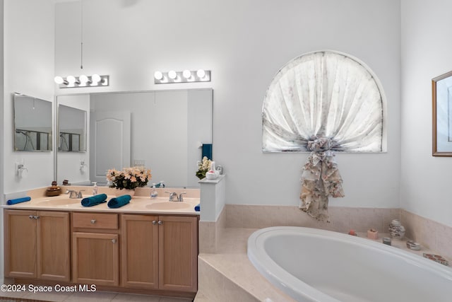 bathroom with vanity and tiled tub