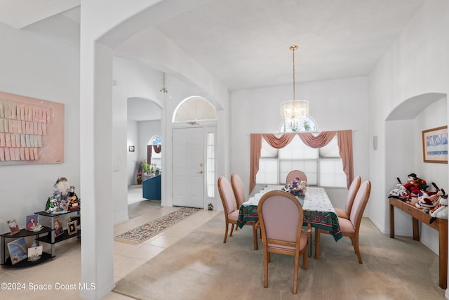 dining area with light tile patterned floors and a chandelier