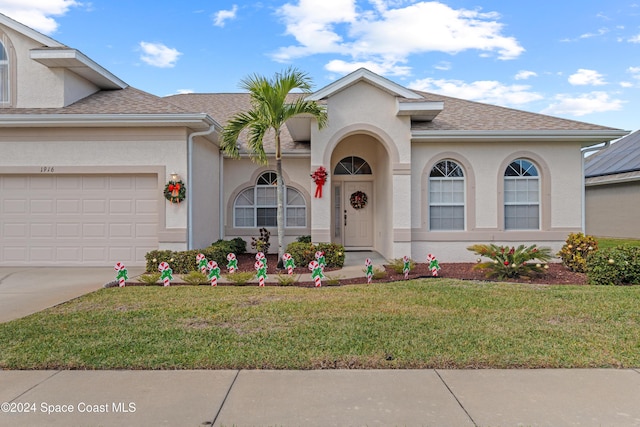 view of front of property with a garage and a front lawn