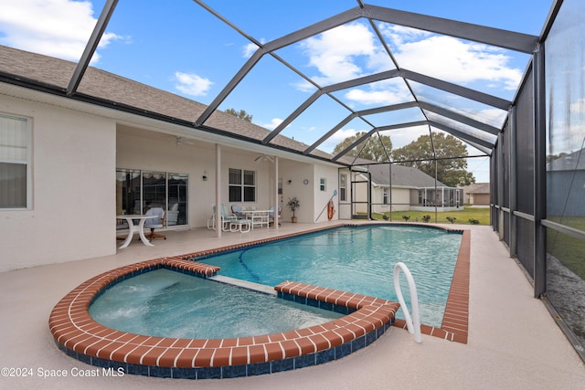 view of pool featuring glass enclosure, ceiling fan, and a patio area