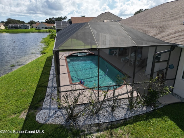 view of pool featuring an in ground hot tub, a lanai, a water view, a patio area, and a yard