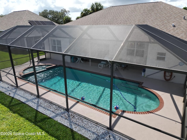 view of pool featuring glass enclosure and a patio area