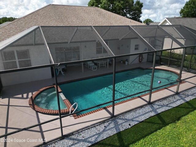 view of pool featuring glass enclosure, an in ground hot tub, and a patio