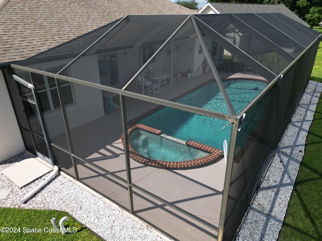 view of swimming pool featuring a lanai, a patio area, and an in ground hot tub