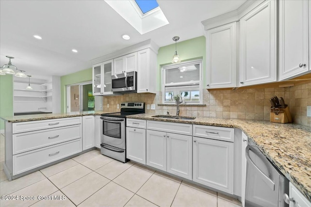 kitchen featuring decorative light fixtures, stainless steel appliances, white cabinetry, and sink