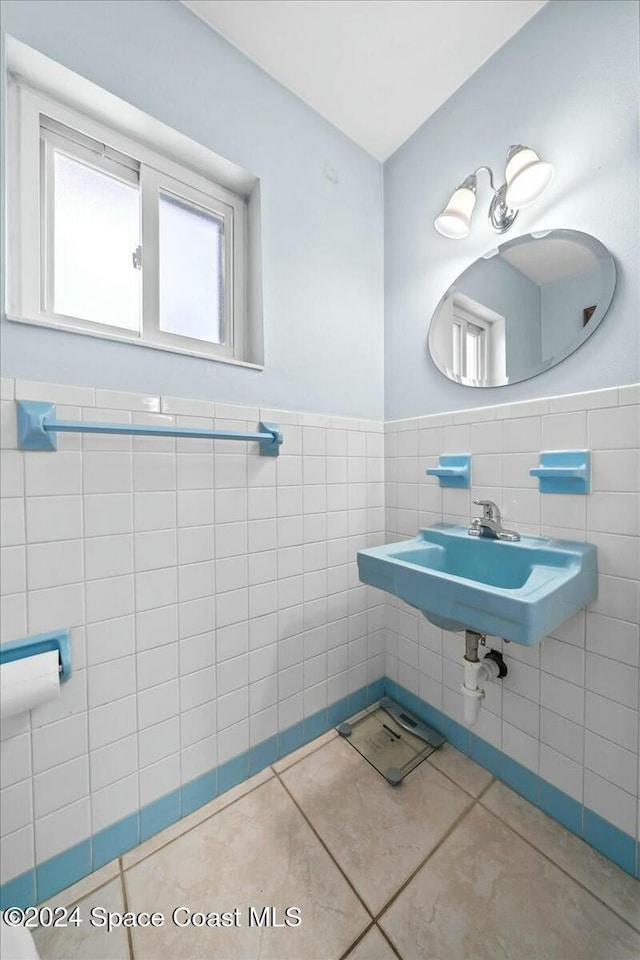 bathroom featuring tile patterned flooring, tile walls, and sink