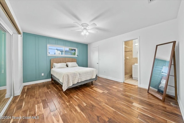 bedroom with hardwood / wood-style flooring, ceiling fan, and ensuite bath