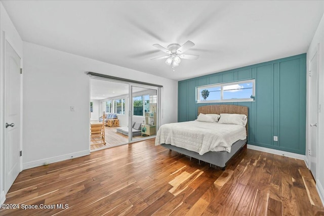 bedroom with ceiling fan, dark hardwood / wood-style flooring, access to outside, and multiple windows