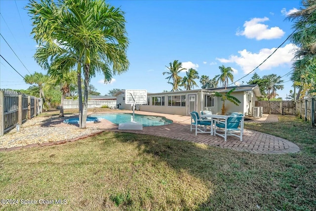 view of pool featuring a sunroom, a patio area, and a lawn