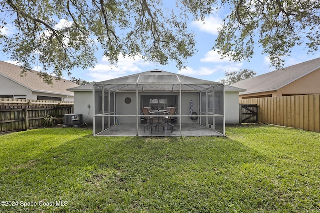 rear view of house with a lawn, a lanai, a patio, and central AC