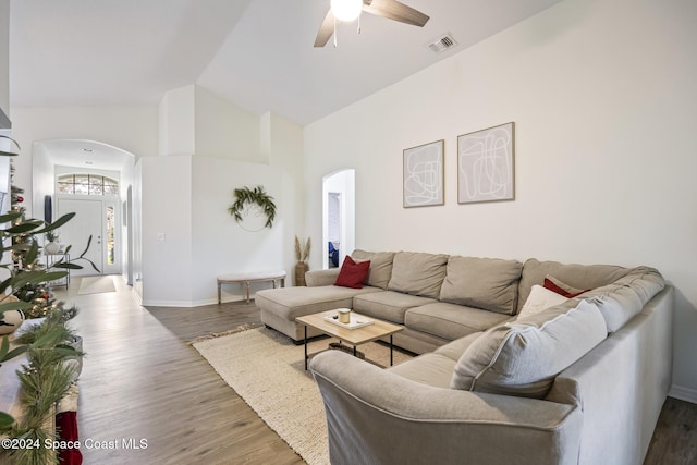 living room featuring dark hardwood / wood-style floors, vaulted ceiling, and ceiling fan